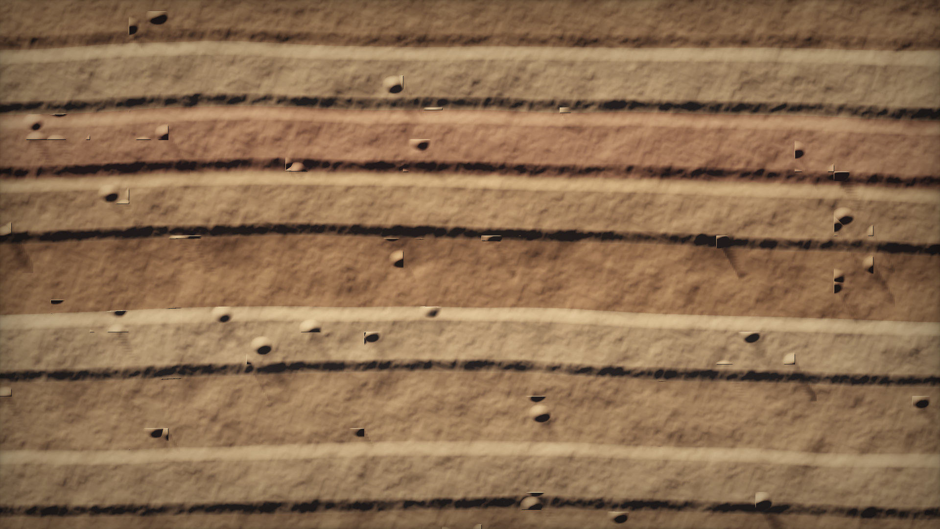 Close view of a rammed-earth wall: horizontal layers of compacted soil in ochre, rust and pale lime.